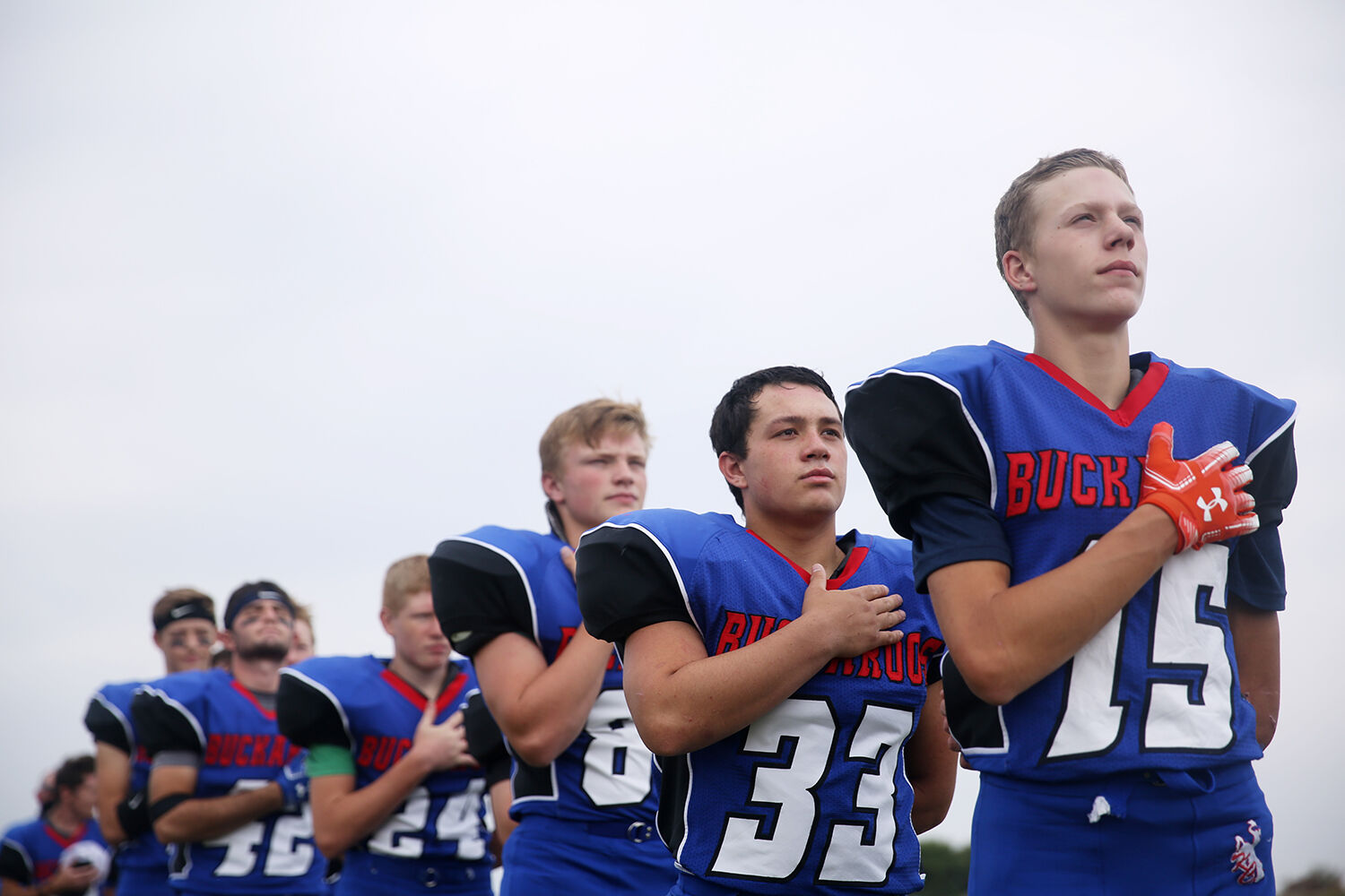 Kaycee High School’s football team lines up for the playing of the National Anthem
